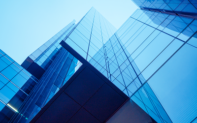 Modern glass skyscrapers against blue sky.